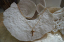 Gold-tone layered necklace design with elongated upper links and a smooth cross pendant on a finer chain.