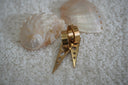 Gold-tone hoop earrings with long triangular drops and graduated circular cut-outs.