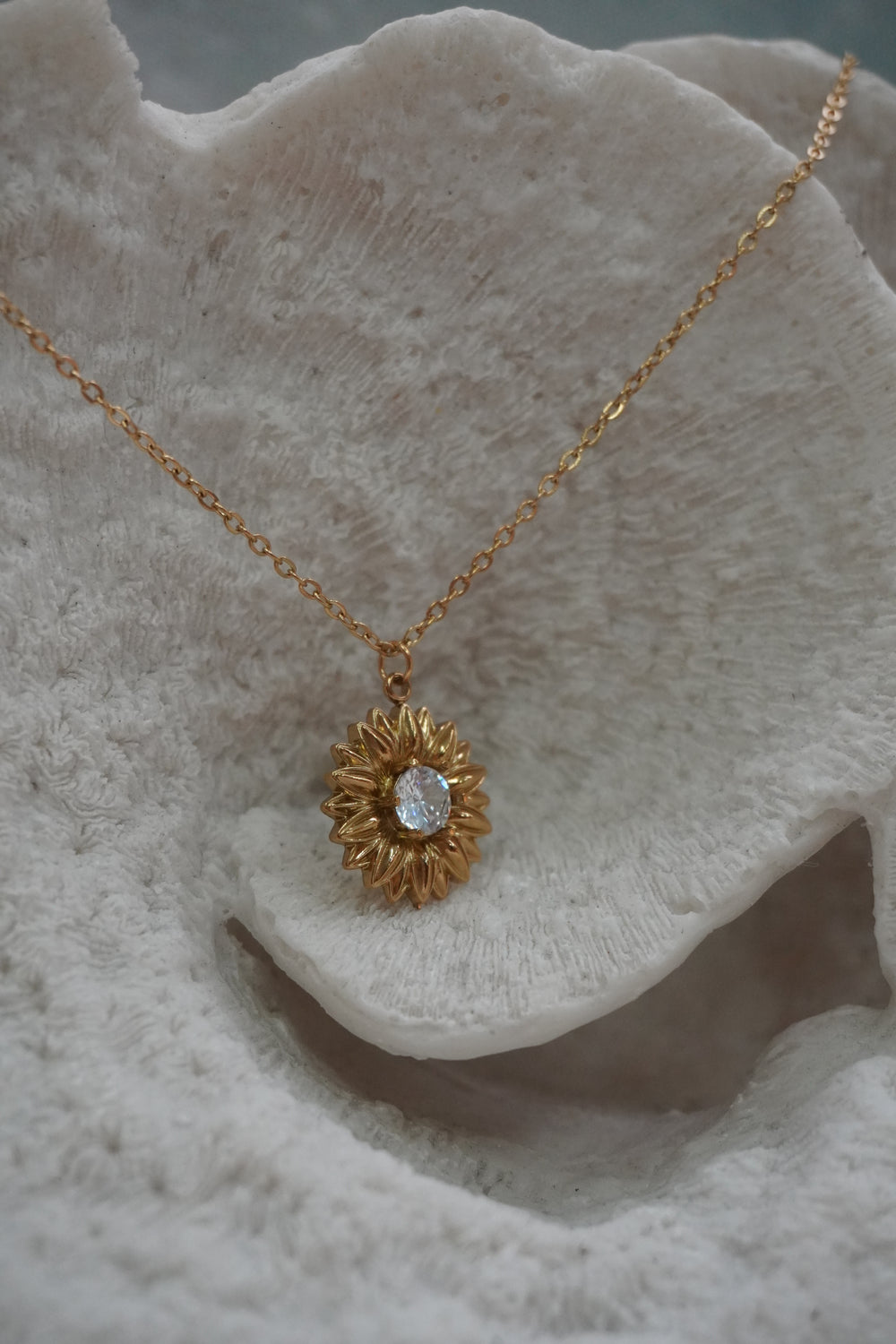Alternate view: gold-tone sunflower pendant necklace with pointed petals and a clear round faceted centre.