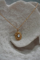 Alternate view: gold-tone sunflower pendant necklace with pointed petals and a clear round faceted centre.