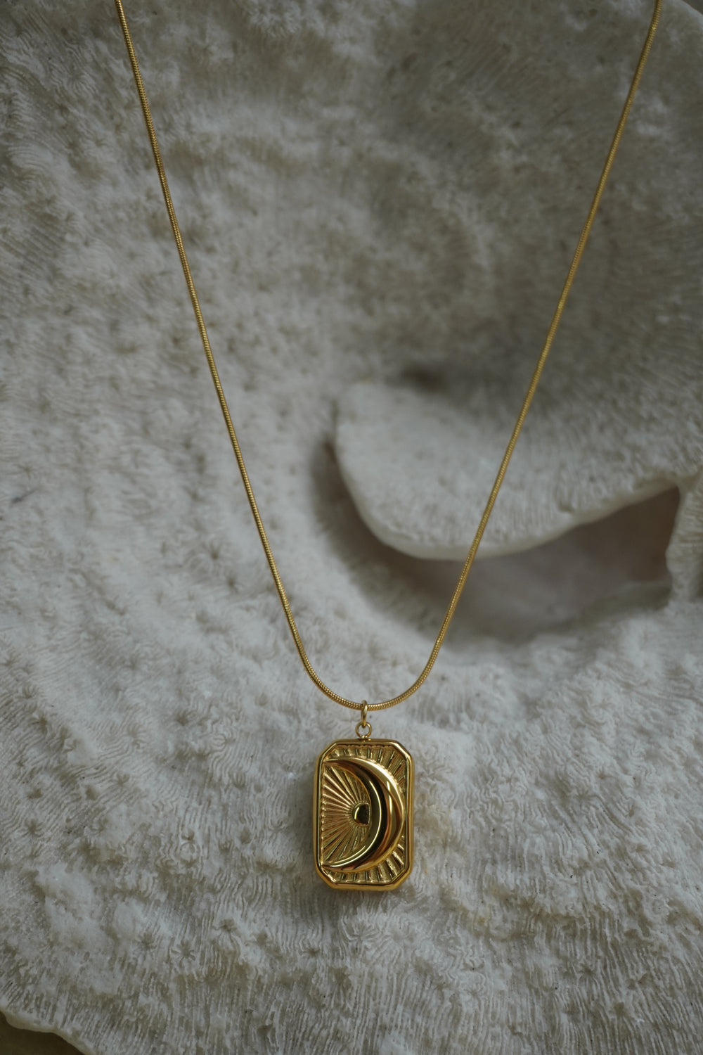 Alternate view: gold-tone necklace with a rectangular crescent-moon and ray pendant.