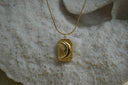 Gold-tone necklace with a rectangular crescent-moon and ray pendant.