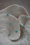 Alternate view: fine gold-tone chain necklace with spaced pairs of blue cylindrical beads and small gold-tone spheres.