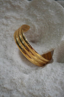 Alternate view: gold-tone open cuff with three broad rounded lengthwise ridges.
