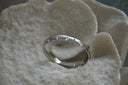 Alternate view: silver-tone bangle with small star motifs and round clear accents.