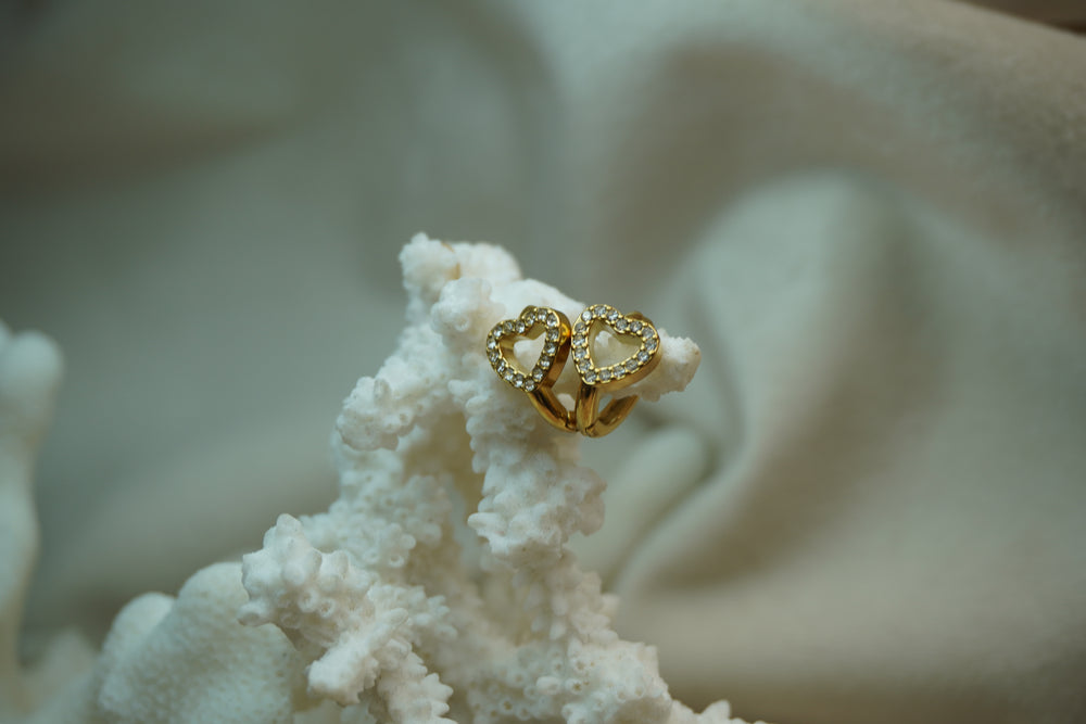 Alternate view: gold-tone hoop earrings with open heart fronts outlined in clear accents.