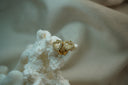 Gold-tone hoop earrings with open heart fronts outlined in clear accents.