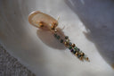 Long drop earrings with round gold-tone studs, fine chains and green, grey and purple-toned beads.