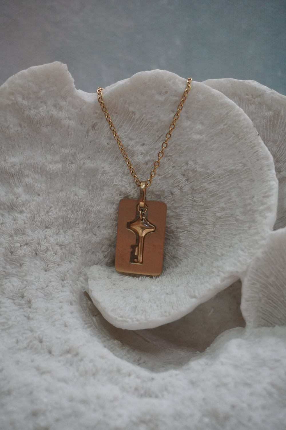 Alternate view: gold-tone chain necklace with a rectangular tag and a key charm with a star-shaped head.