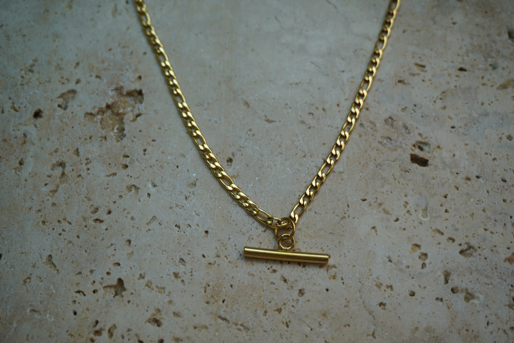 Gold-tone necklace with alternating chain links and a smooth horizontal bar suspended at the centre.