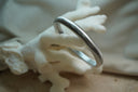 Alternate view: silver-tone rounded bangle with closely spaced ribs around the band.
