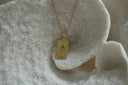 Gold-tone necklace with a rectangular Justice pendant, sword-and-scales illustration and XI lettering.