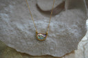 Necklace with an iridescent striped half-circle centre, ridged gold-tone border and fine chain.