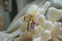 Alternate view: gold-tone hoops with small round purple beads, larger irregular purple drops and reflective charms.
