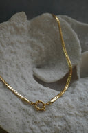 Gold-tone necklace with flattened curb-style links and a round front clasp.