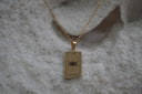 Gold-tone necklace with a rectangular The High Priestess pendant, triple-moon illustration and II lettering.