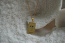 Gold-tone necklace with a rectangular The Fool pendant showing a heart wearing sunglasses and 0 lettering.