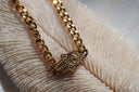 Gold-tone chain bracelet with a hand-shaped centrepiece, eye motif and raised dot details.