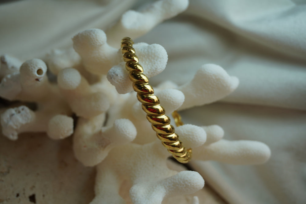 Alternate view: gold-tone open cuff with rounded diagonal twisted ridges.