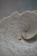 Alternate view: gold-tone necklace with shell and starfish charms, a small clear accent and elongated central links.