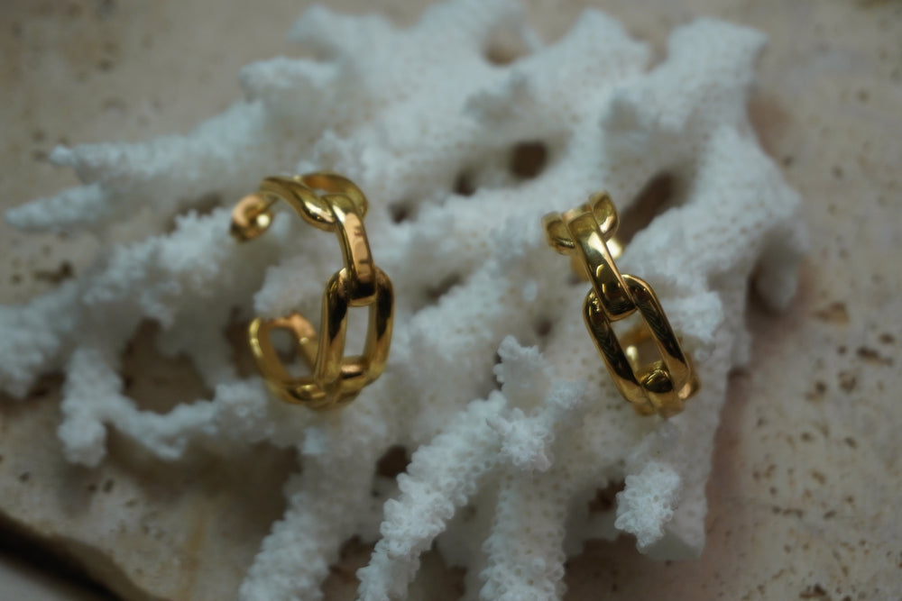 Gold-tone open hoop earrings formed from interlocking rounded rectangular links.