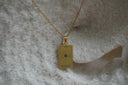 Alternate view: gold-tone necklace with a rectangular The World pendant, orbital circles, small dots and XXI lettering.