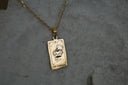 Gold-tone necklace with a rectangular The Emperor pendant, crown-and-arrow illustration and IV lettering.