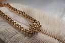 Gold-tone chain bracelet with a ship-wheel centrepiece and rounded spoke tips.