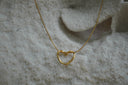 Gold-tone necklace with an open heart-outline pendant.