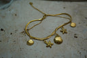 Alternate view: gold-tone bracelet with layered strands and hanging shell and starfish motifs.
