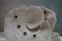 Alternate view: gold-tone chain necklace with spaced black four-lobed motifs in gold-tone borders.