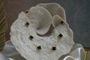 Gold-tone chain necklace with spaced black four-lobed motifs in gold-tone borders.