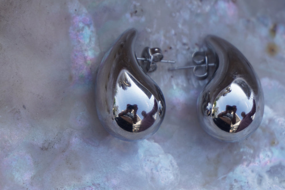 Alternate view: silver-tone teardrop stud earrings with rounded bases, curved tips and visible posts.