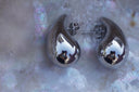 Alternate view: silver-tone teardrop stud earrings with rounded bases, curved tips and visible posts.