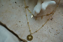Alternate view: layered gold-tone necklace arrangement with small cross drops above a bead-station chain and a star-marked round disc.