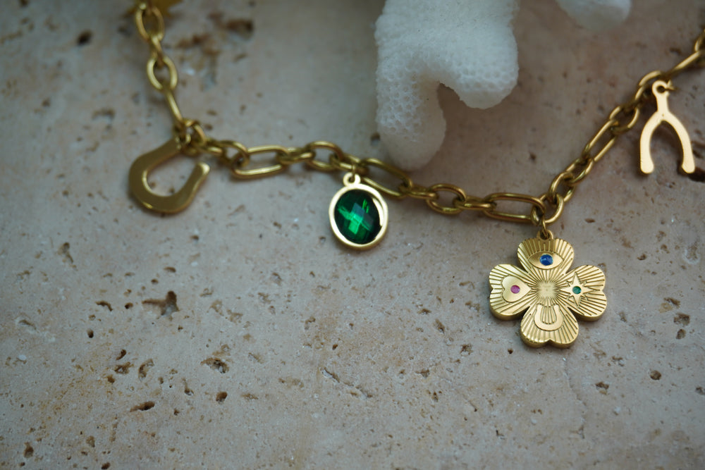 Alternate view: gold-tone link necklace with horseshoe, wishbone and clover charms, a green oval accent and multicoloured details.