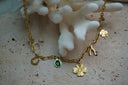 Gold-tone link necklace with horseshoe, wishbone and clover charms, a green oval accent and multicoloured details.