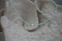 Alternate view: pale-aqua seed-bead necklace with a white centre bead and small gold-tone spacers.