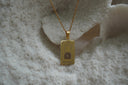 Gold-tone necklace with a rectangular The Chariot pendant, framed canopy illustration and VII lettering.