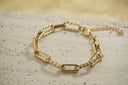 Gold-tone bracelet with alternating smooth and textured rectangular links, a clasp and extension chain.