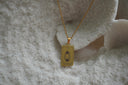 Gold-tone necklace with a rectangular The Hermit pendant, lantern illustration and IX lettering.