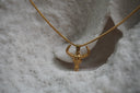 Alternate view: gold-tone necklace with a narrow horned skull pendant, raised forehead details and a closely linked chain.