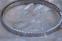Alternate view: silver-tone bangle with repeating rectangular ridges around the band.