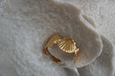 Gold-tone open cuff formed from broad ridged fan-shell shapes.