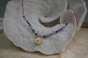 Alternate view: multicoloured beaded necklace with a gold-tone circular medallion and pink centre.