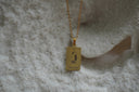 Alternate view: gold-tone necklace with a rectangular The Lovers pendant, linked-hands illustration and VI lettering.
