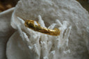 Gold-tone open cuff with smooth sections and raised diagonal bands.
