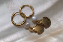 Alternate view: gold-tone hoop earrings with white rounded beads and hanging ridged scallop-shell charms.