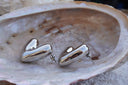 Alternate view: silver-tone sculpted heart stud earrings with asymmetric rounded lobes and visible posts.