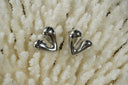 Silver-tone sculpted heart stud earrings with asymmetric rounded lobes and visible posts.